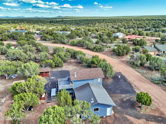 drone / aerial view with a wooded view and a mountain view