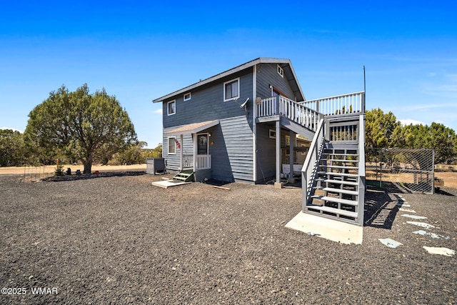 rear view of house with stairway and a wooden deck