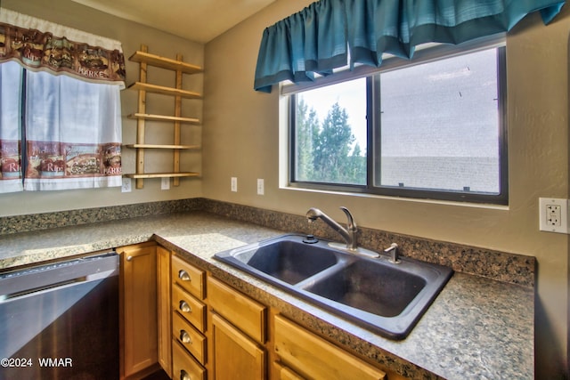 kitchen featuring dark countertops, brown cabinets, dishwasher, and a sink
