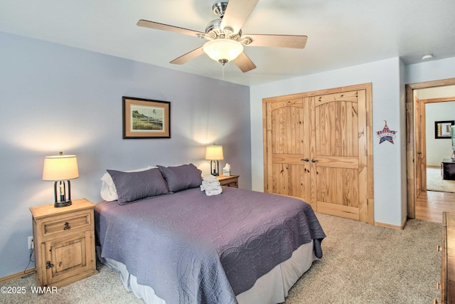 bedroom with light colored carpet, a closet, ceiling fan, and baseboards