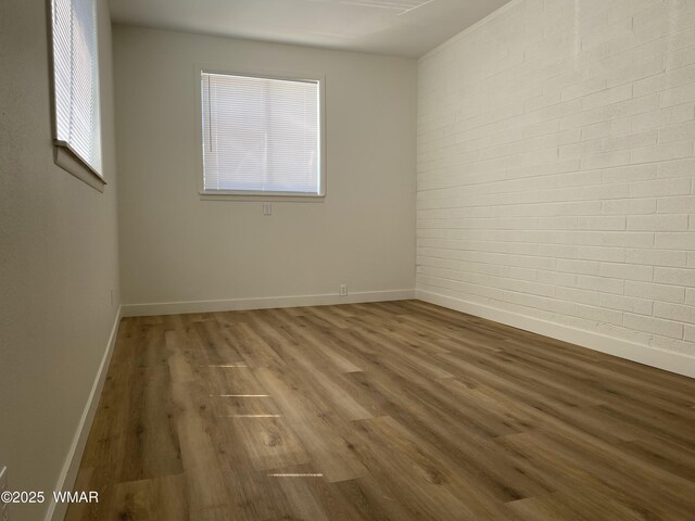 242 E 7th Ave, Eagar, AZ 85925 - empty room featuring wood finished floors and brick wall