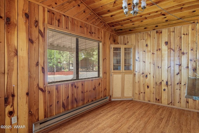 1721 W Huning, Show Low, AZ 85901 - empty room featuring baseboard heating, a chandelier, lofted ceiling, wood walls, and light wood-style floors