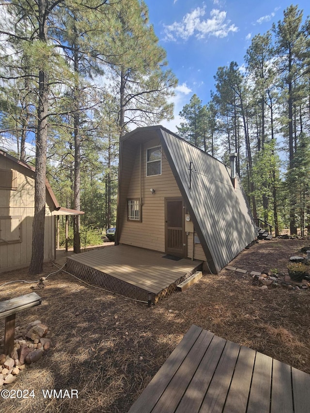 exterior space featuring metal roof, a deck, and a gambrel roof