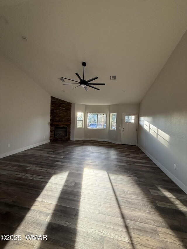 2747 Air Park Dr, Overgaard, AZ 85933 - unfurnished living room with ceiling fan, a stone fireplace, baseboards, wood finished floors, and vaulted ceiling