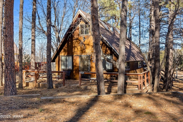 rear view of house with a shingled roof