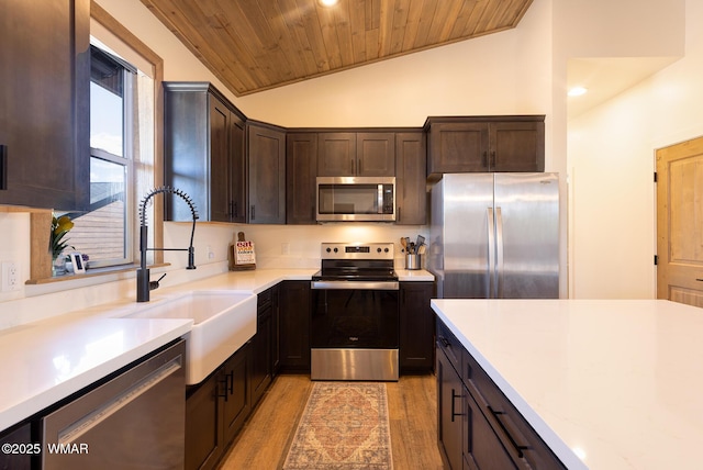 kitchen featuring stainless steel appliances, a sink, wooden ceiling, light wood-style floors, and dark brown cabinets