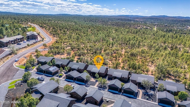 aerial perspective of suburban area featuring a heavily wooded area and mountains