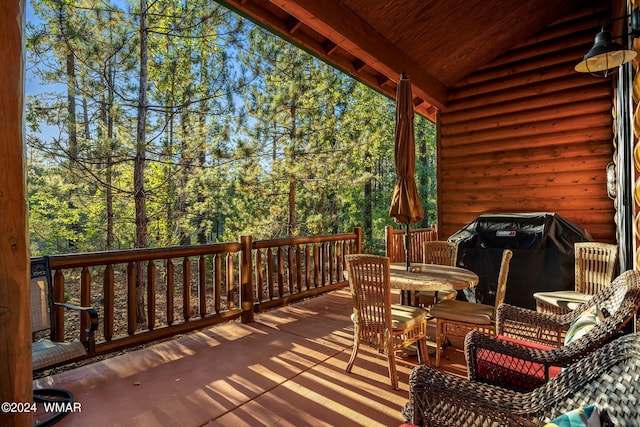 wooden deck with outdoor dining area and a grill