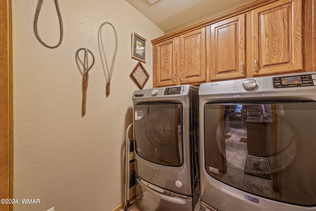 washroom featuring cabinet space and washer and clothes dryer