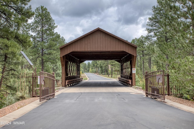 surrounding community with a detached carport, driveway, and a gate