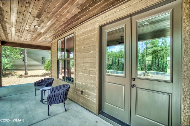 doorway to outside featuring wooden ceiling, concrete flooring, and a wealth of natural light