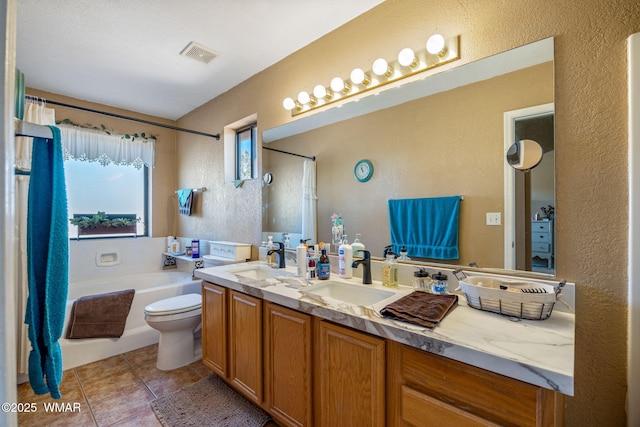 bathroom featuring tile patterned floors, visible vents, a sink, and double vanity