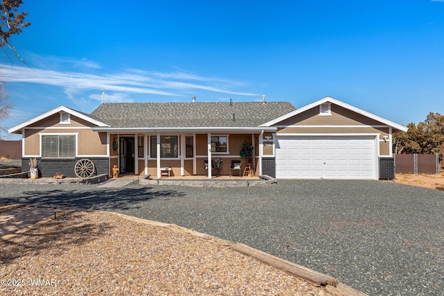 ranch-style home with a garage, covered porch, brick siding, and driveway