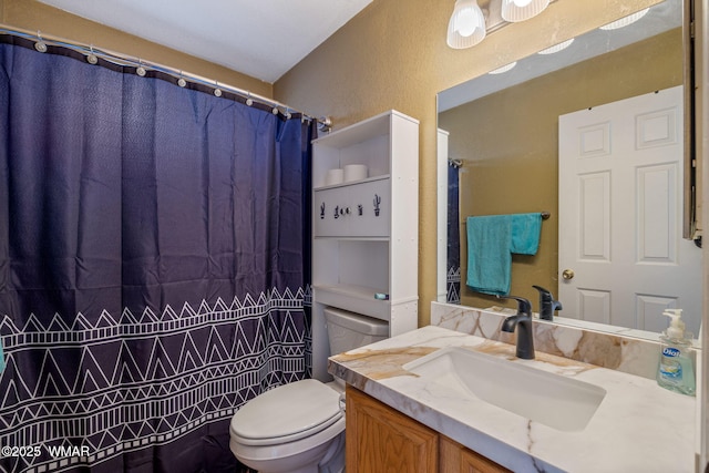 full bathroom with toilet, a textured wall, and vanity