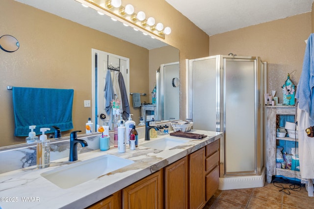 bathroom featuring tile patterned flooring, a sink, and a shower stall