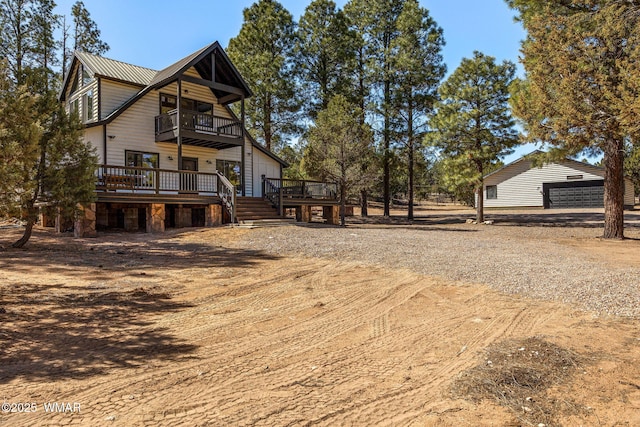 view of side of property featuring a balcony and metal roof