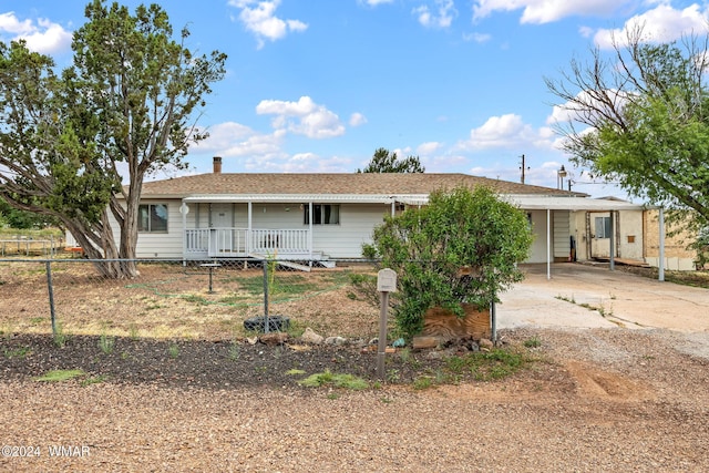 back of property with driveway and a carport