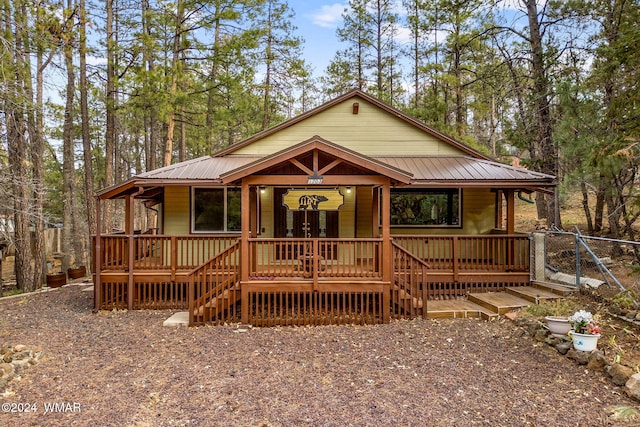 chalet / cabin featuring covered porch and metal roof