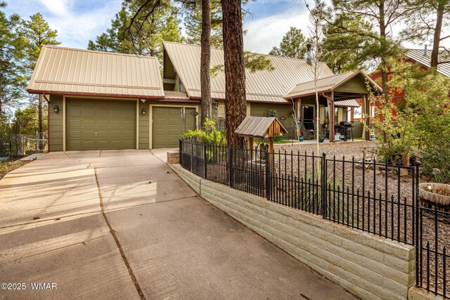 2331 W Rogers Loop, Show Low, AZ 85901 - view of front of home featuring concrete driveway, an attached garage, and metal roof