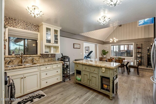 2331 W Rogers Loop, Show Low, AZ 85901 - kitchen with a chandelier, a sink, lofted ceiling, light wood finished floors, and tasteful backsplash
