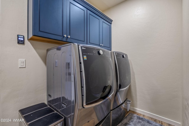 laundry area with washer and dryer, cabinet space, baseboards, and wood finished floors