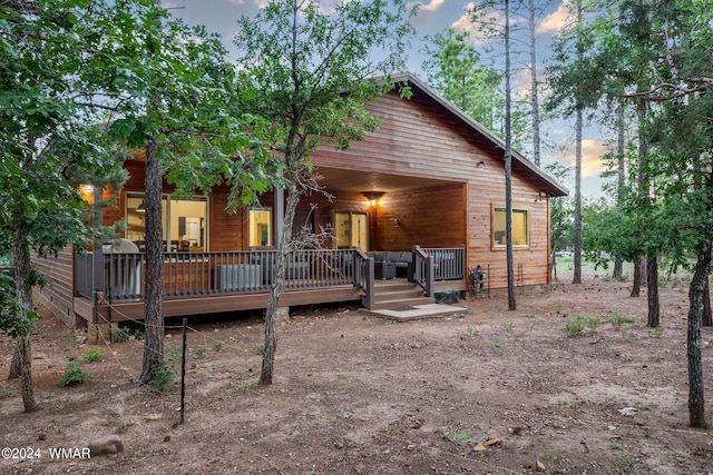 rear view of house featuring a wooden deck