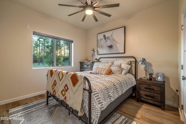 bedroom featuring baseboards, ceiling fan, and light wood finished floors