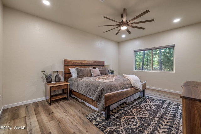 bedroom with light wood-type flooring, baseboards, and recessed lighting