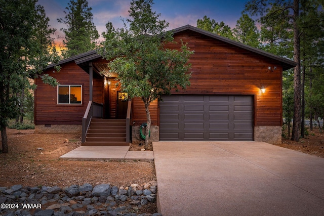 rustic home with a garage, concrete driveway, and crawl space