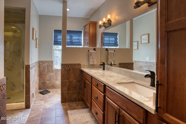 bathroom with tile patterned flooring, a shower stall, double vanity, and a sink