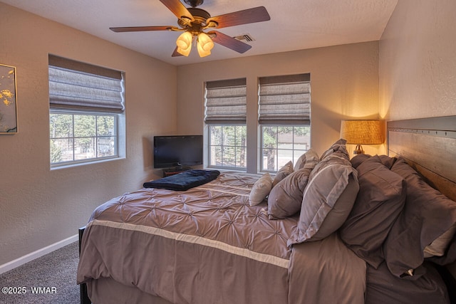 bedroom featuring visible vents, carpet floors, multiple windows, and a textured wall