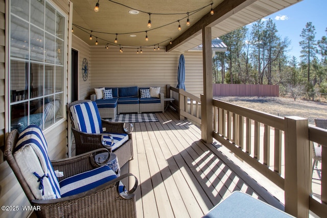 wooden terrace with outdoor lounge area and fence