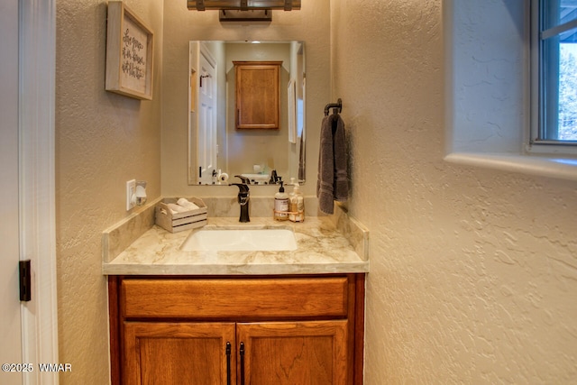 bathroom featuring vanity and a textured wall