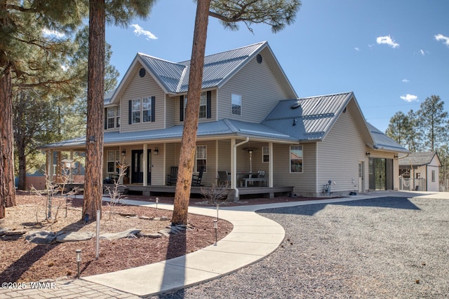 back of house with covered porch and metal roof