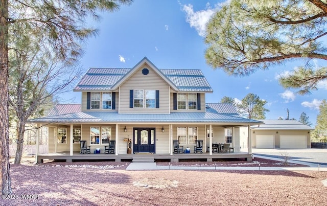 farmhouse with metal roof, a garage, a porch, and driveway