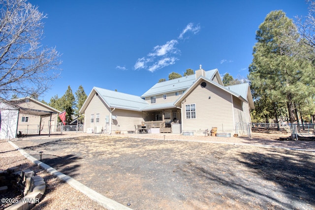 rear view of house with fence and a chimney