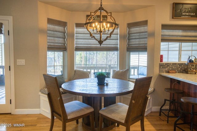 dining area with an inviting chandelier, wood finished floors, and baseboards