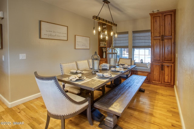 dining area with baseboards and light wood finished floors