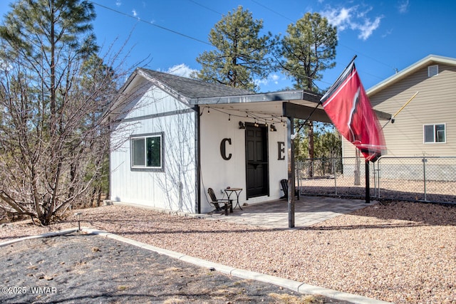 view of outbuilding with a gate, an outdoor structure, and fence