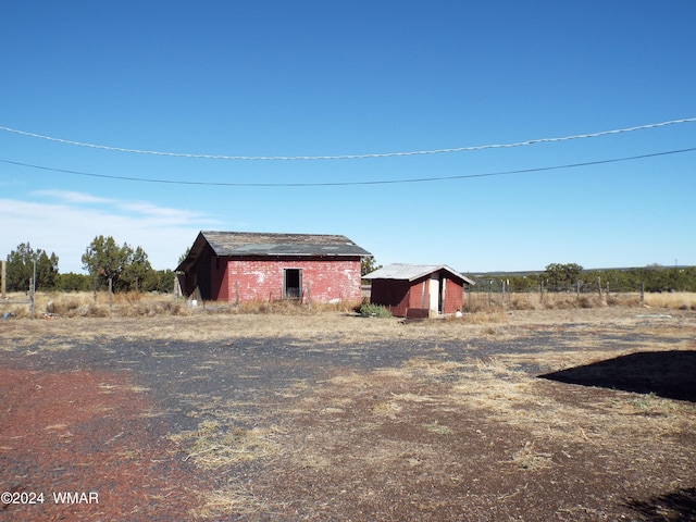 view of yard featuring an outbuilding and a rural view