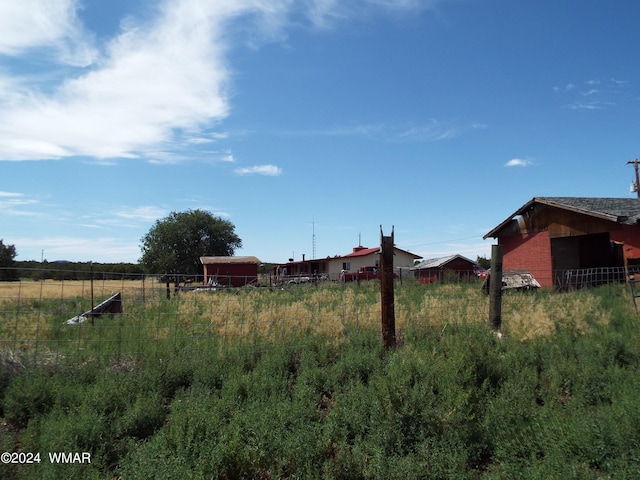 view of yard featuring a rural view and fence