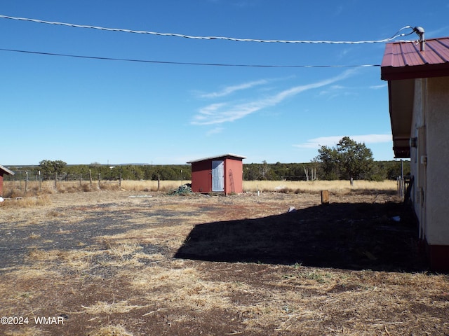 view of yard with an outbuilding, a rural view, and a storage unit