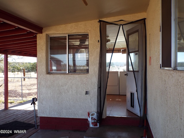 entrance to property featuring independent washer and dryer and stucco siding