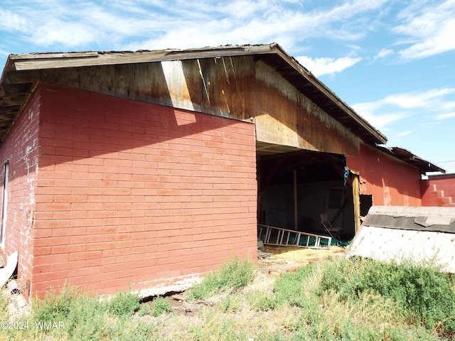 view of property exterior with an outbuilding and brick siding