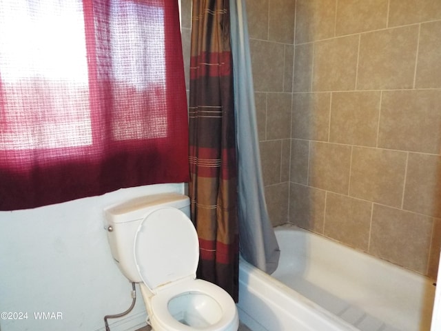 bathroom featuring shower / bath combo with shower curtain and toilet