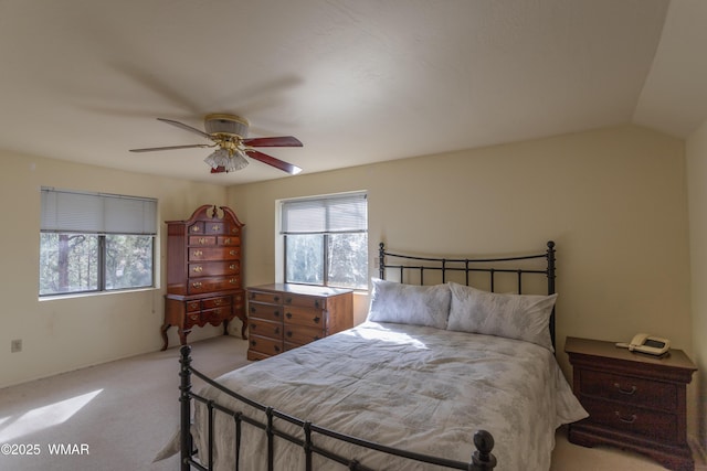 bedroom with ceiling fan, vaulted ceiling, and light colored carpet