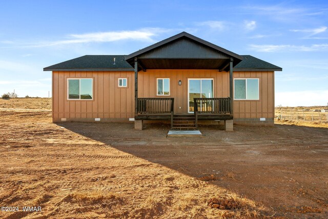 rear view of property featuring a shingled roof, crawl space, and a deck