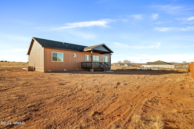 rear view of house with crawl space and fence