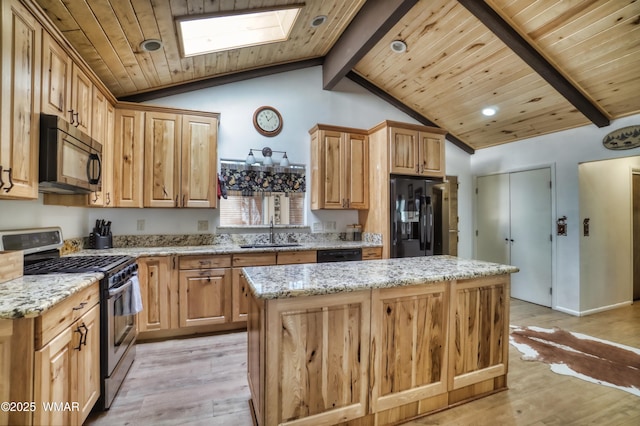 kitchen featuring a sink, black appliances, light stone counters, and a kitchen island