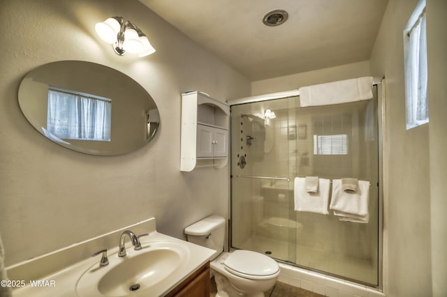 bathroom with toilet, a stall shower, and vanity